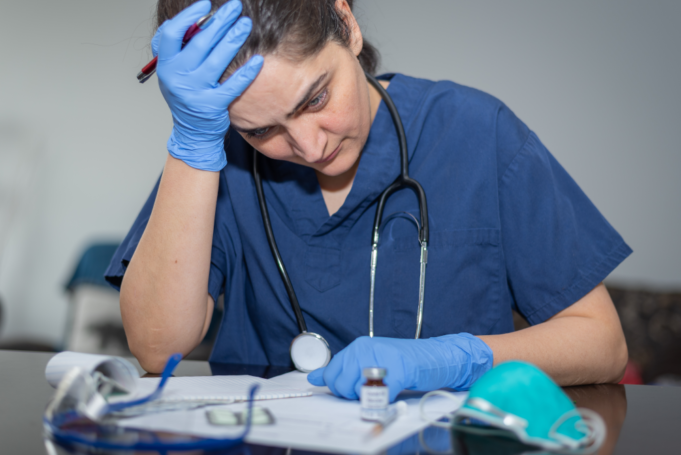 An image of a stressed nurse representing the importance of nurse wellness.